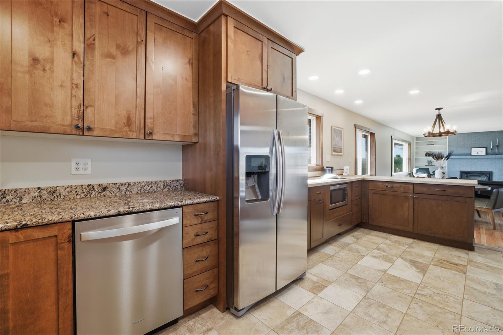 2097 West Wolfensberger Road Castle Rock, CO 80109 - Photo 18 of 48 a kitchen with stainless steel appliances granite countertop a refrigerator a sink dishwasher with wooden cabinets and floor