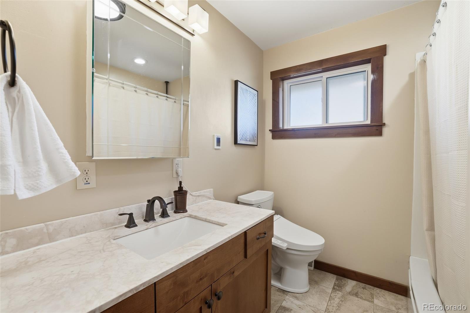 2097 West Wolfensberger Road Castle Rock, CO 80109 - Photo 22 of 48 a bathroom with a granite countertop sink toilet and mirror