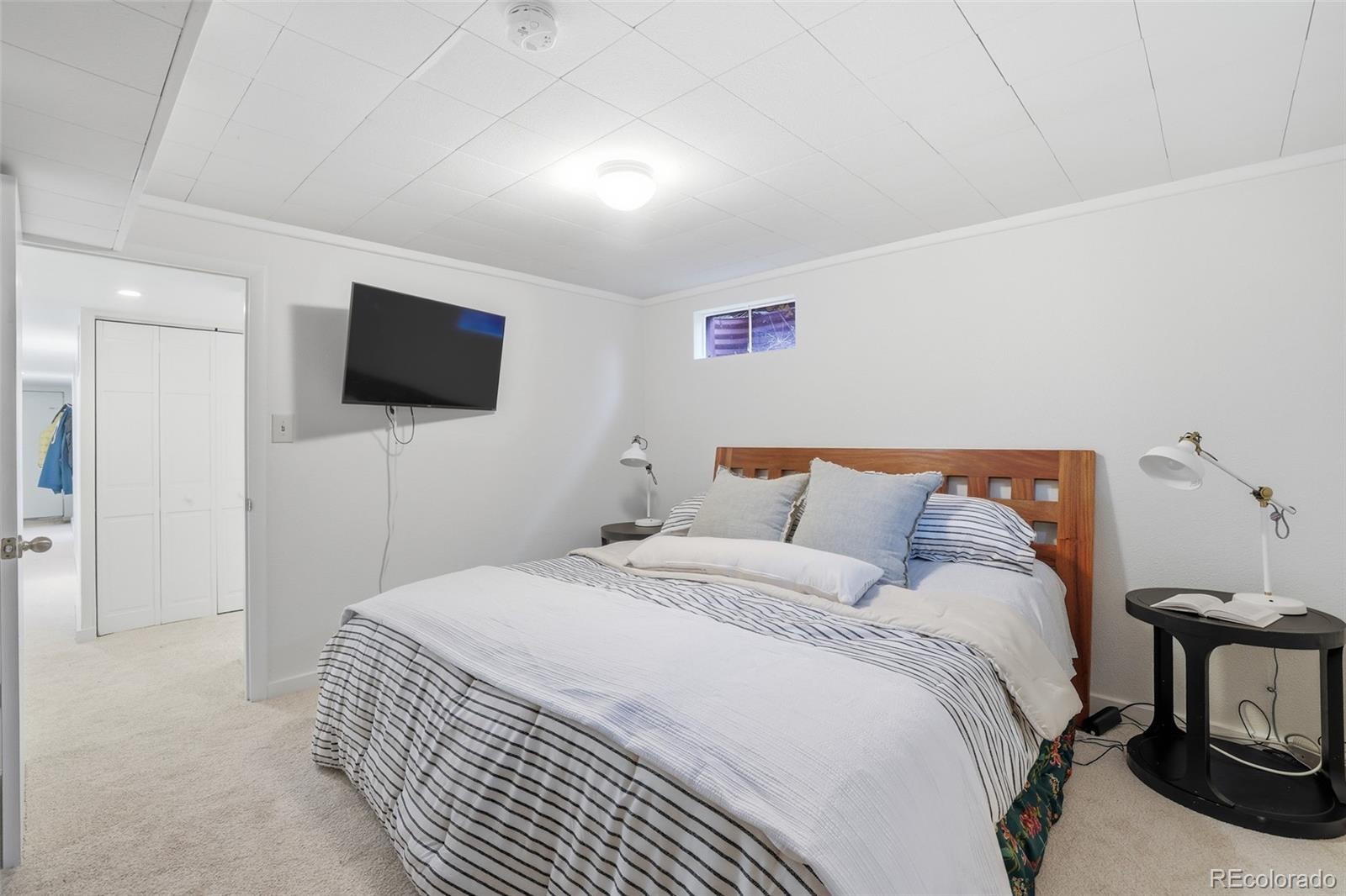 2097 West Wolfensberger Road Castle Rock, CO 80109 - Photo 29 of 48 a bedroom with a bed and a flat screen tv