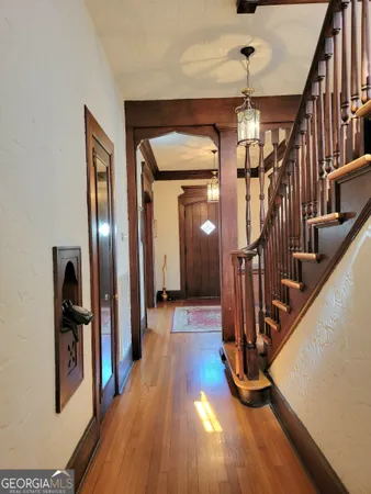 a view of a hallway with wooden floor and staircase