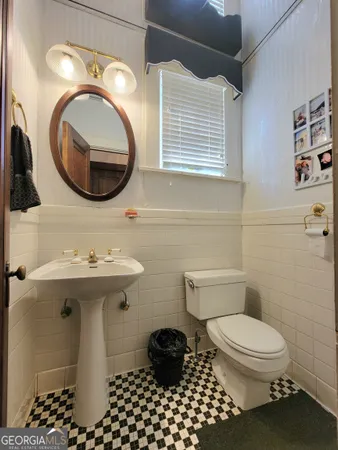 a bathroom with a sink a toilet and mirror