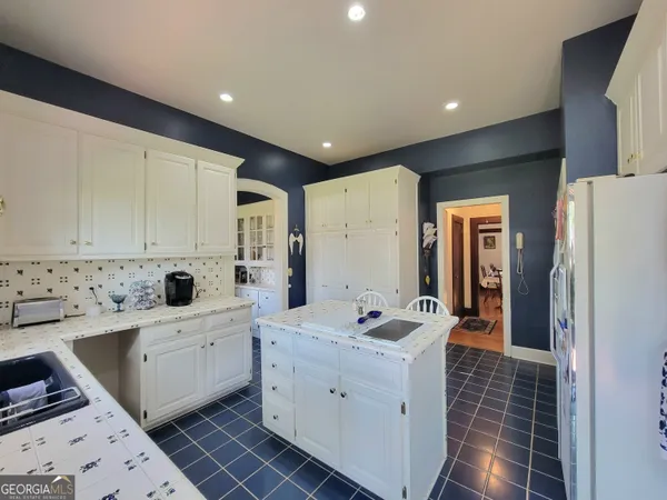 a room with a white cabinets and white appliances