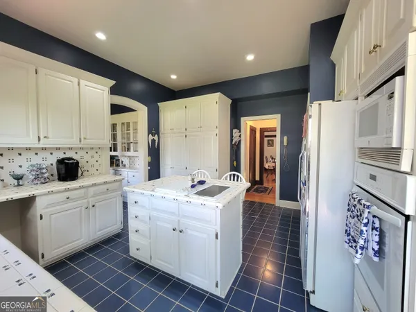 a kitchen with white cabinets and white appliances