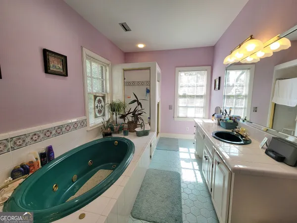 a bathroom with a sink a bathtub and a window