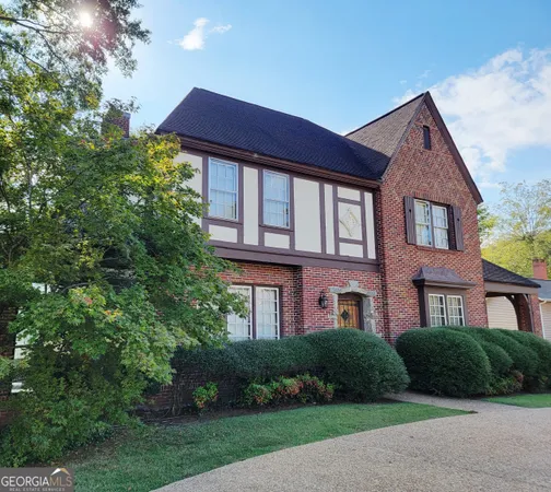 a front view of a house with a yard and trees