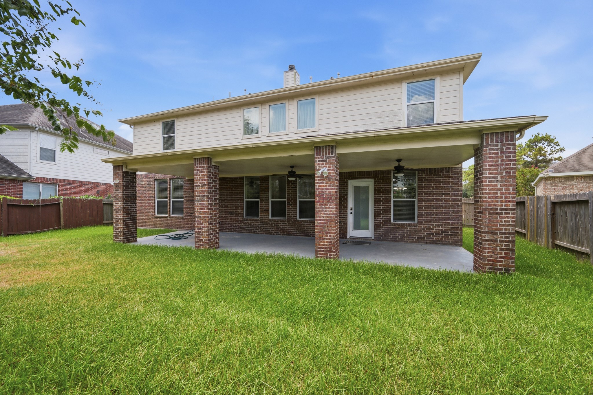 2117 Rushing Spring Drive Pearland, TX 77584 - Photo 41 of 42 Expansive and inviting, the back of this home features a spacious covered patio with brick columns, perfect for outdoor relaxation and entertainment.