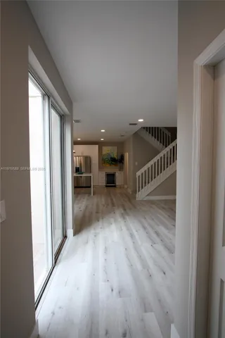 a view of kitchen with kitchen island wooden floor center island and stainless steel appliances