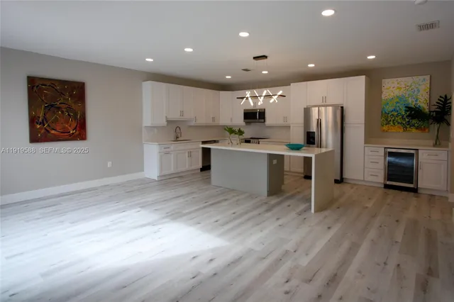 a kitchen with stainless steel appliances a refrigerator sink and microwave