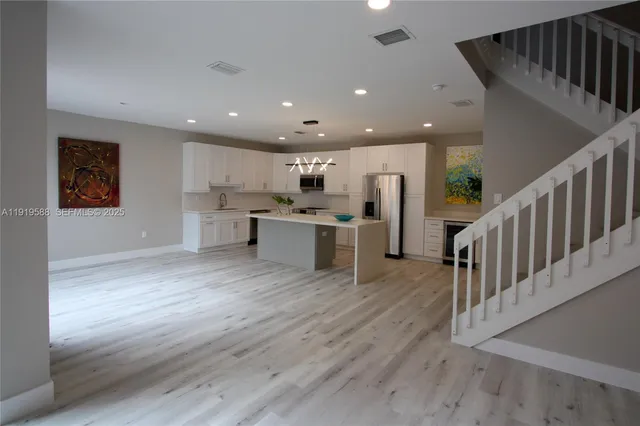 a view of kitchen with wooden floor and electronic appliances