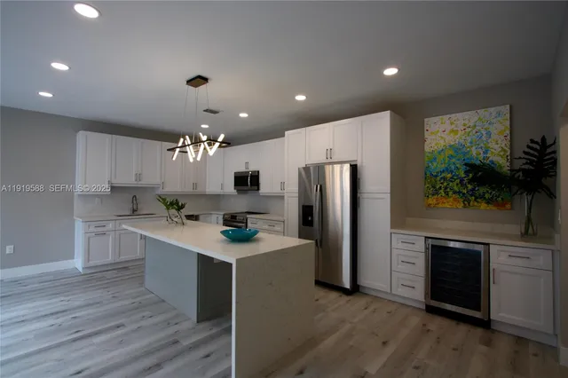 a kitchen with stainless steel appliances a sink a stove top oven a counter space and cabinets