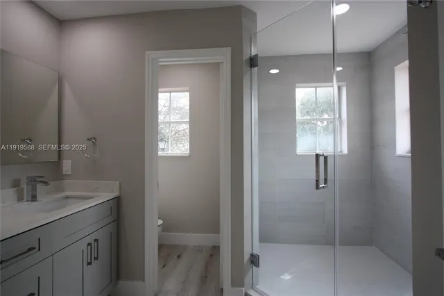 a bathroom with a shower sink and mirror