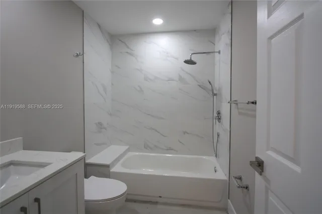 a bathroom with a granite countertop toilet a sink and bathtub