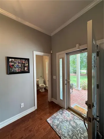 a view of a bedroom with wooden floor and balcony