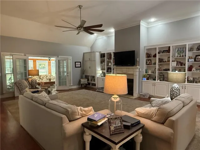 a living room with furniture a dining table and a flat screen tv