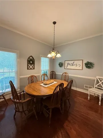 a dining room with furniture a chandelier and wooden floor