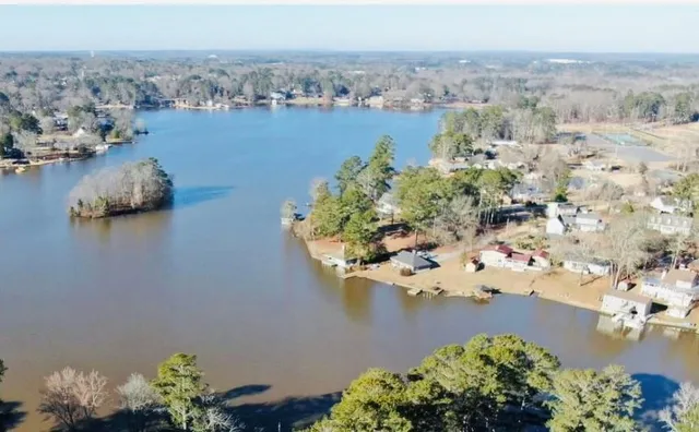 an aerial view of a house with a yard and lake view