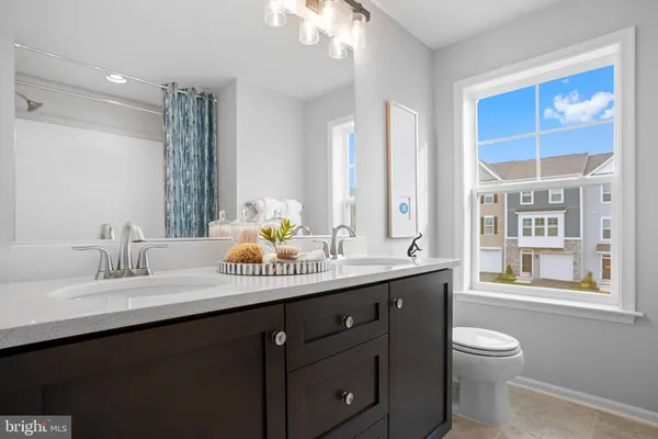 a bathroom with a granite countertop sink a toilet and a mirror