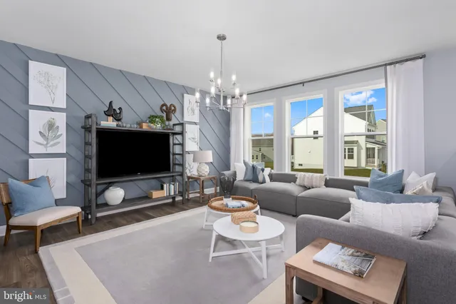 a living room with furniture a flat screen tv and a large window