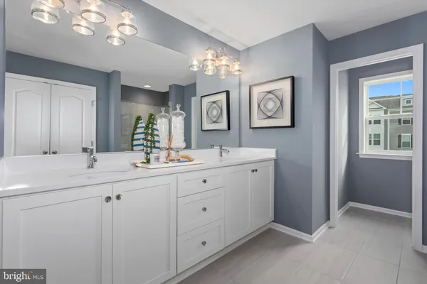 a spacious bathroom with a double vanity sink a mirror and a window