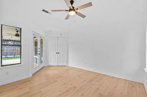 an empty room with fan and windows