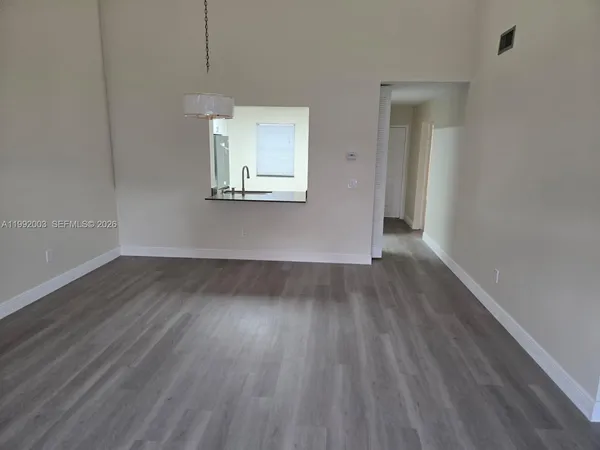 a view of a room with wooden floor and window