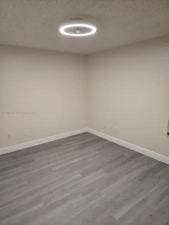 a view of a room with wooden floor and fan