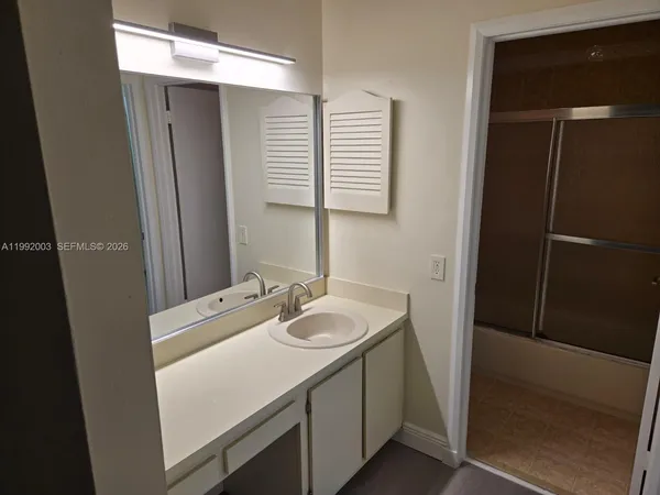 a bathroom with a sink a mirror and a shower