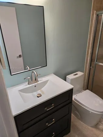 a bathroom with a sink a toilet a mirror and vanity