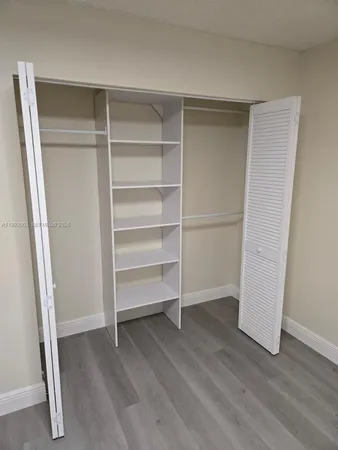 a view of walk in closet with empty racks