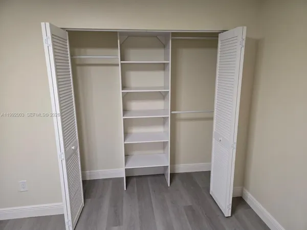 a view of walk in closet with empty racks