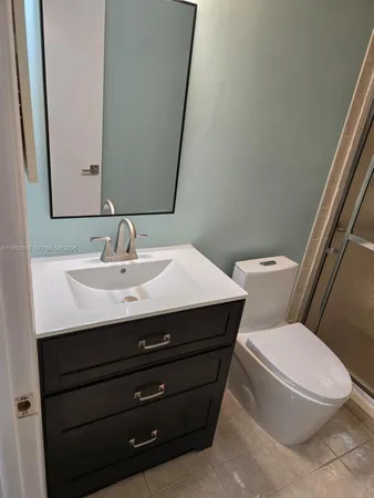 a bathroom with a sink mirror vanity and toilet