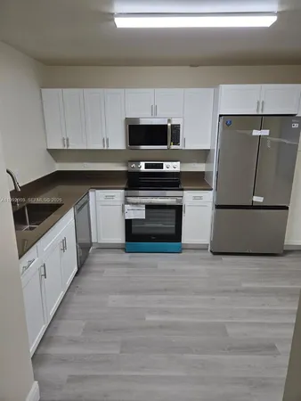 a kitchen with granite countertop a sink and a stove top oven