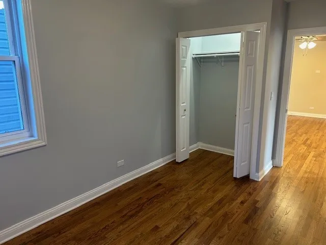 an empty room with wooden floor and closet