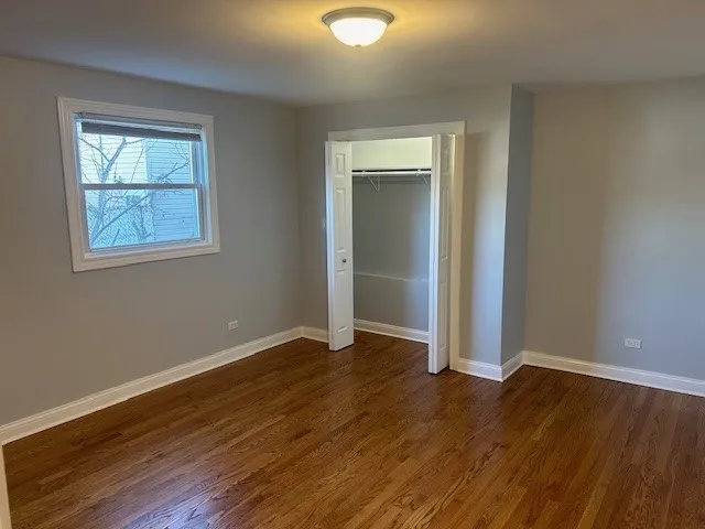 an empty room with wooden floor and closet