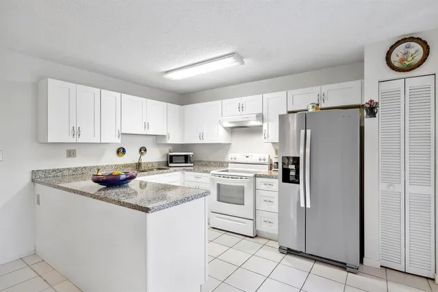 a kitchen with white cabinets and white appliances