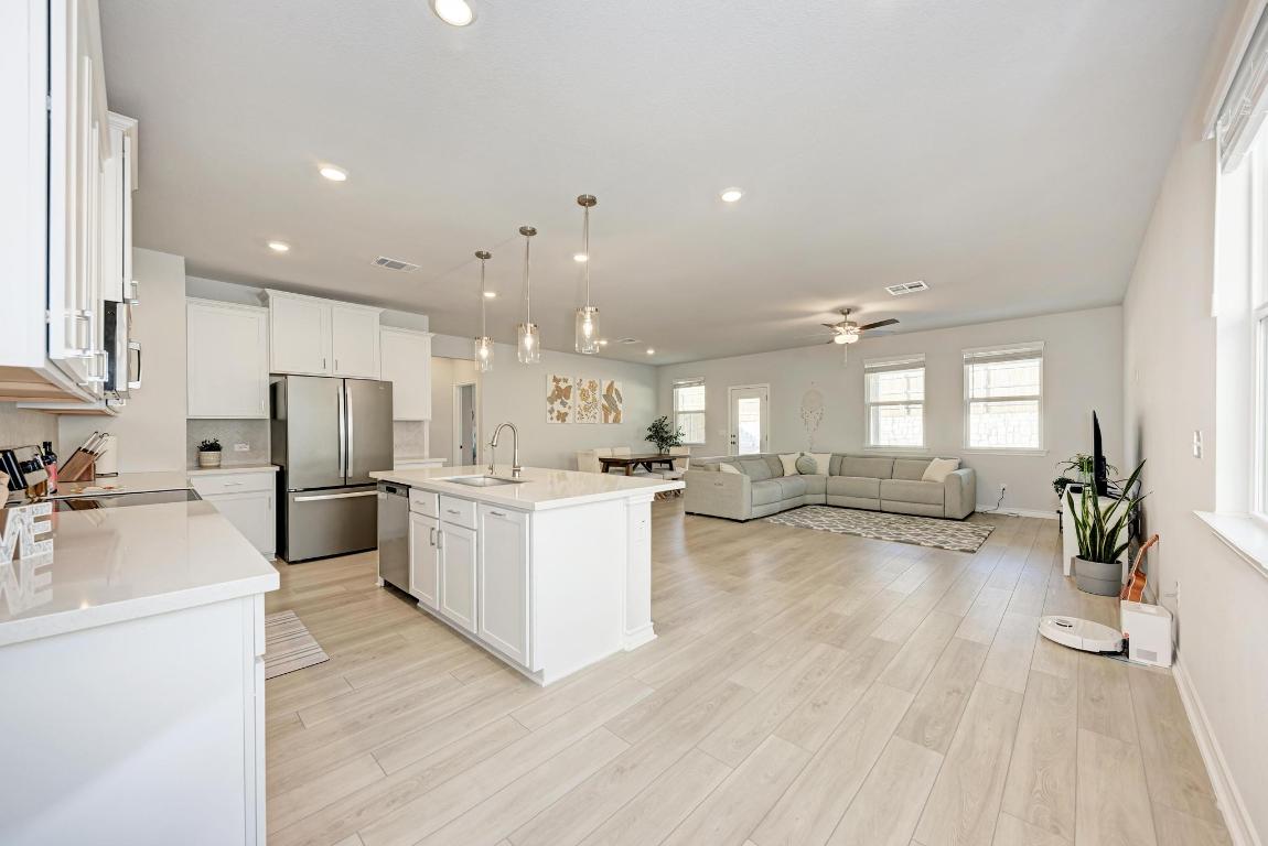 113 Rampart Loop Liberty Hill, TX 78642 - Photo 38 of 40 a kitchen with sink cabinets and wooden floor