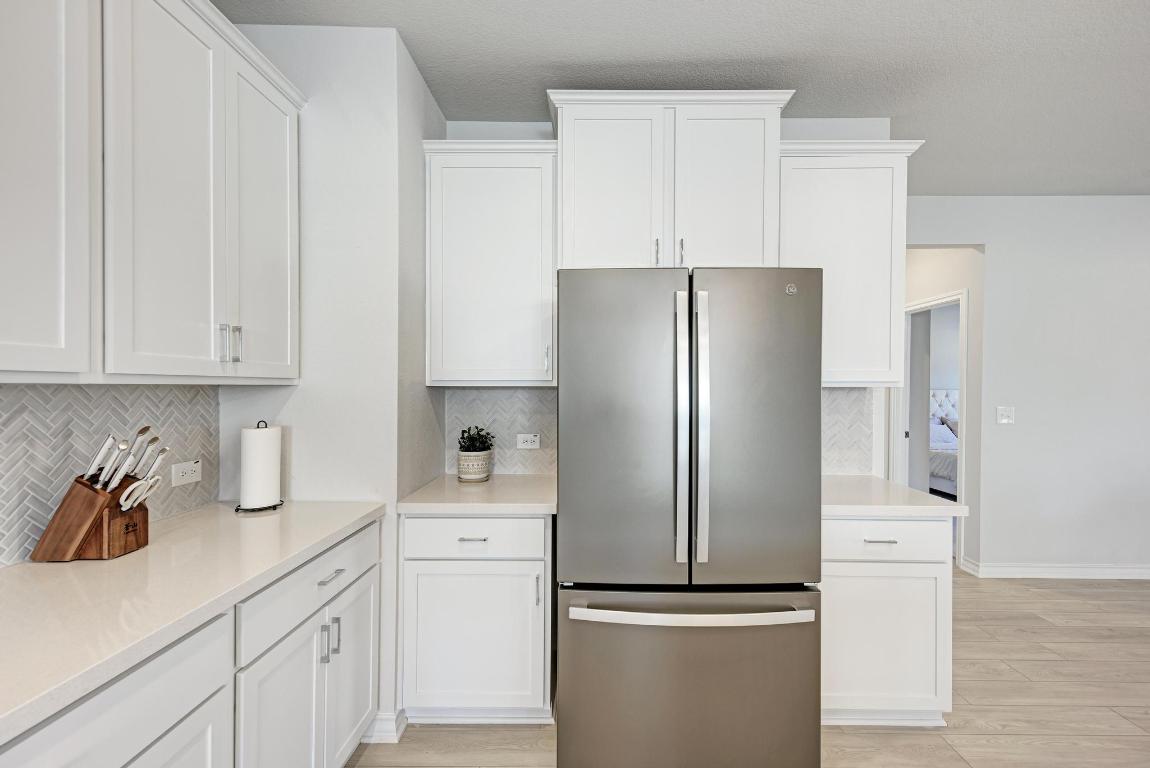 113 Rampart Loop Liberty Hill, TX 78642 - Photo 9 of 40 a kitchen with appliances a refrigerator and cabinets
