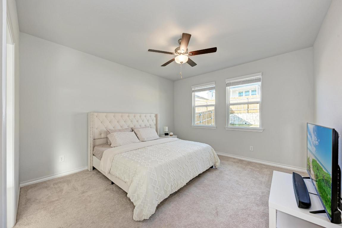 113 Rampart Loop Liberty Hill, TX 78642 - Photo 15 of 40 a bedroom with a bed tv and a window