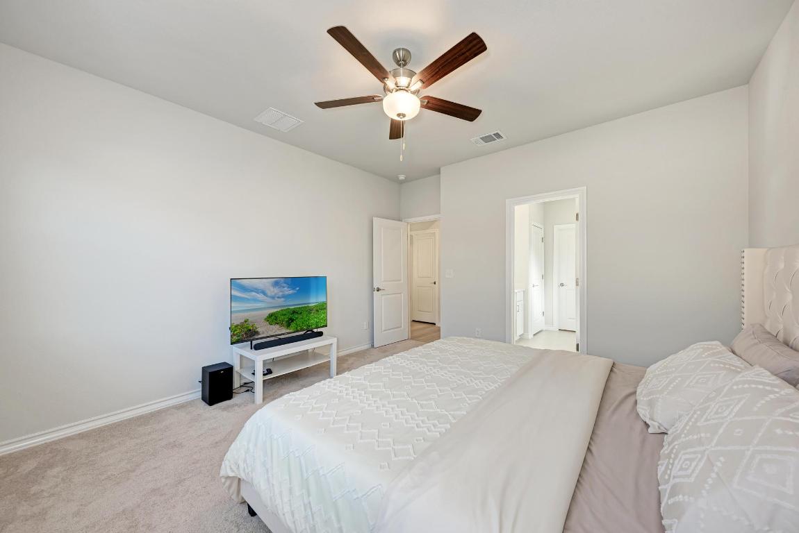 113 Rampart Loop Liberty Hill, TX 78642 - Photo 16 of 40 a bedroom with a bed and a large window