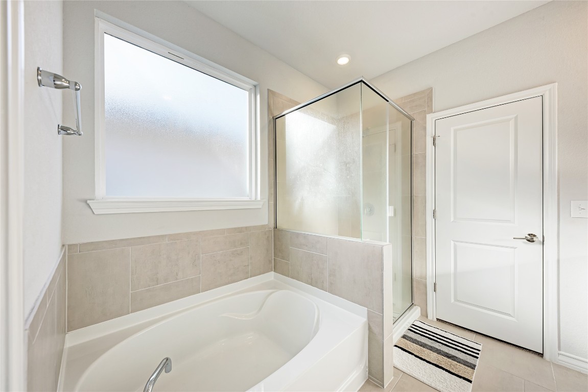 113 Rampart Loop Liberty Hill, TX 78642 - Photo 18 of 40 a bathroom with a bathtub and a shower