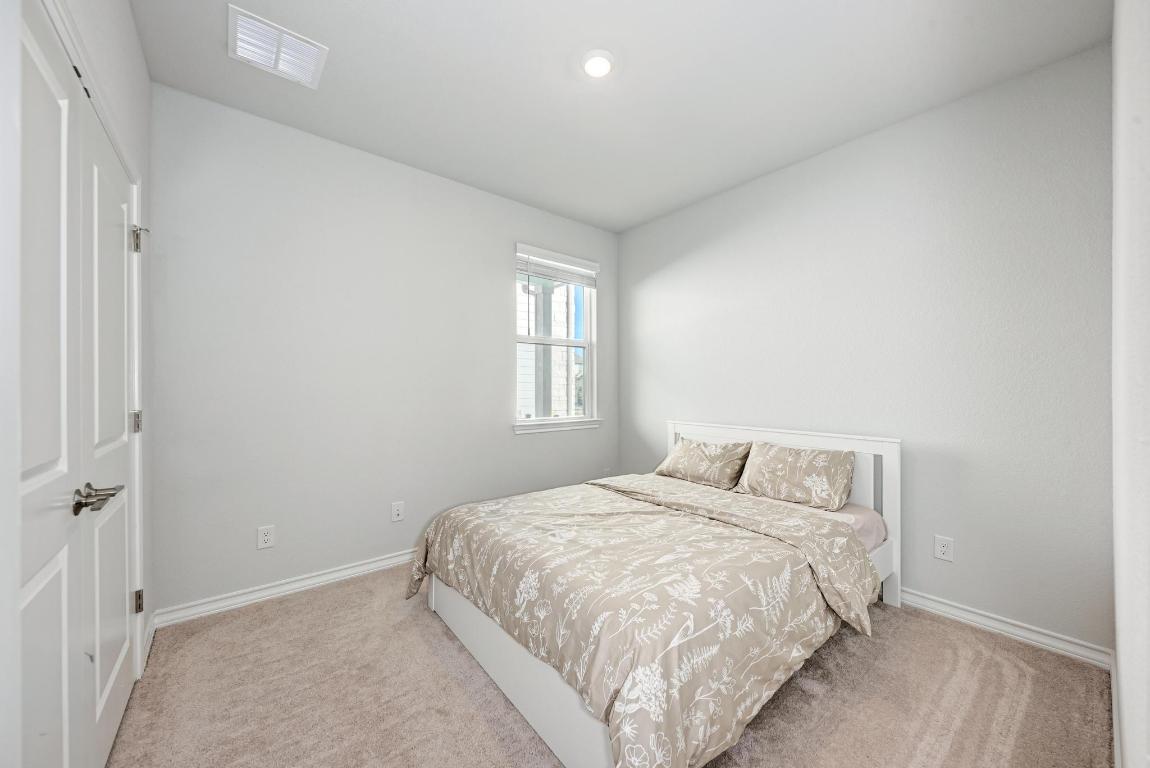 113 Rampart Loop Liberty Hill, TX 78642 - Photo 23 of 40 a bedroom with a bed and a window