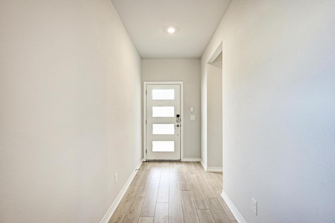 113 Rampart Loop Liberty Hill, TX 78642 - Photo 4 of 40 a view of a hallway with wooden floor and closet