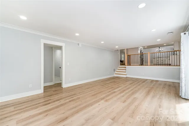 an empty room with bed and a ceiling fan