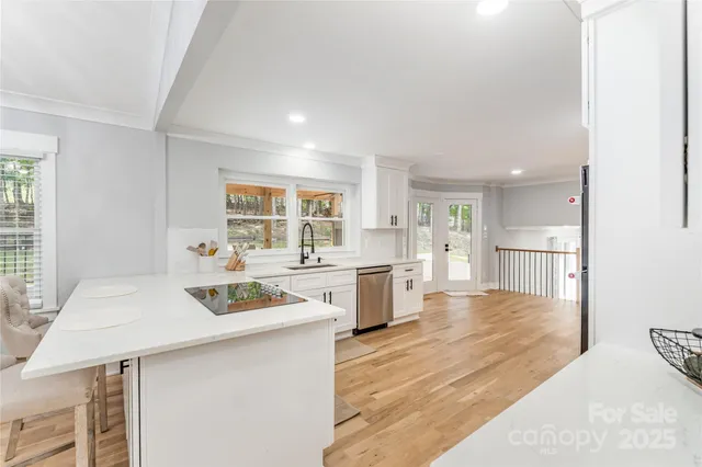 a kitchen with stainless steel appliances kitchen island granite countertop a sink cabinets and wooden floor