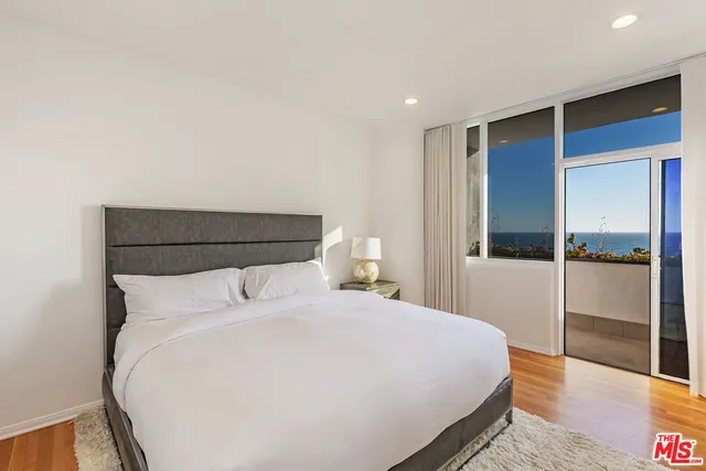 a large bed in a bedroom next to a window