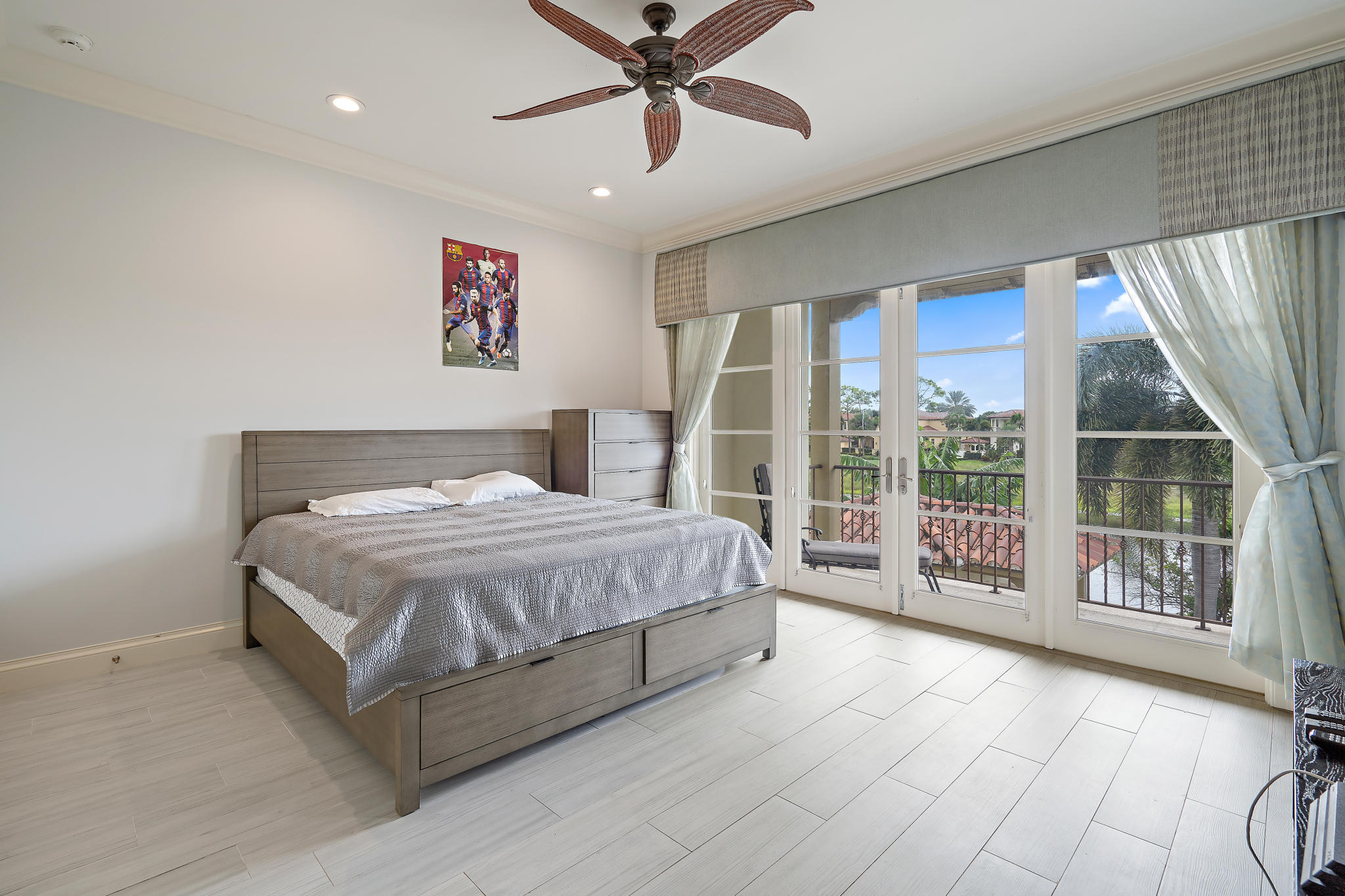 426 Red Hawk Drive Jupiter, FL 33477 - Photo 27 of 40 a spacious bedroom with a large bed and a chandelier