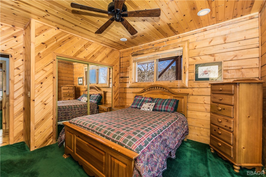 43574 Shasta Road Big Bear Lake, CA 92315 - Photo 13 of 37 a bedroom with a bed a dresser next to a window