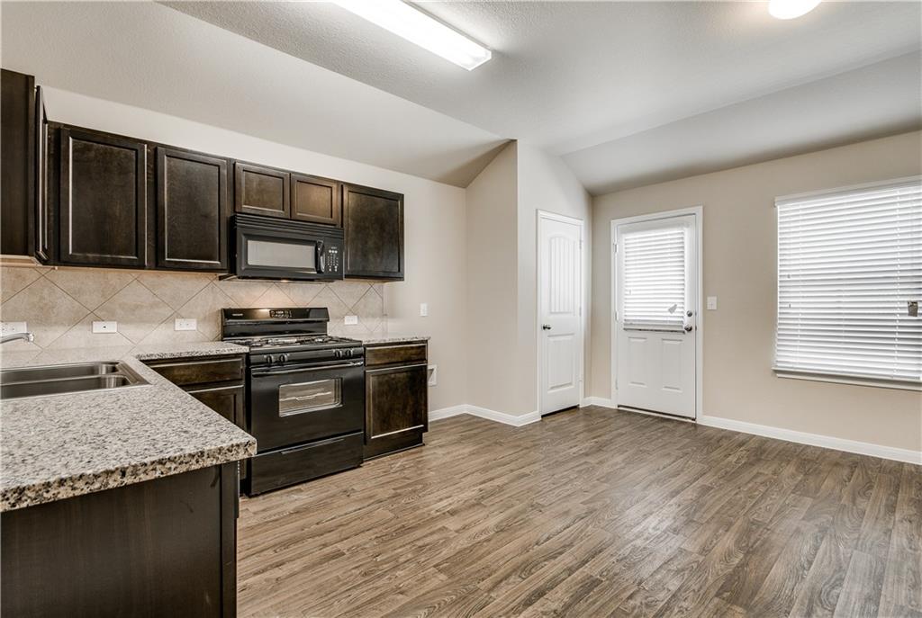 185 Voss Kyle, TX 78640 - Photo 5 of 26 a kitchen with granite countertop a stove and a sink