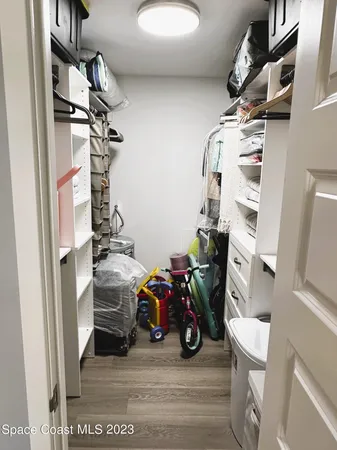 a view of walk in closet with clothes and shoes