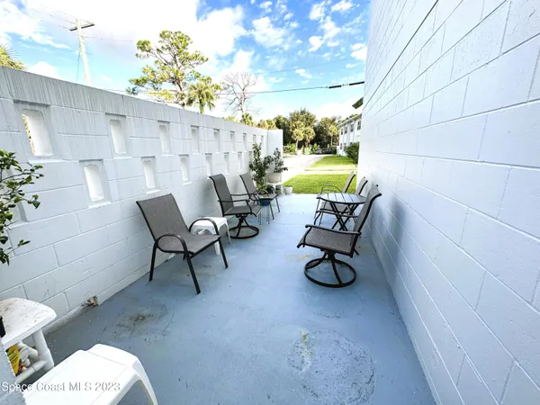 a view of patio with a table and chairs and potted plants